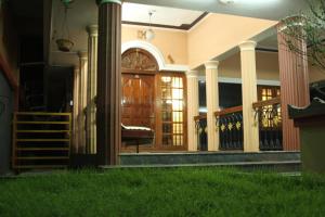 a front porch with a wooden door and a chair at ShivalayaHomestay in Trichūr