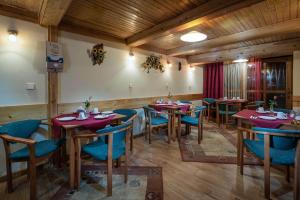 ein Restaurant mit Holztischen und blauen Stühlen in der Unterkunft Vila House Family in Poprad