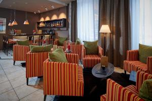 ein Wartezimmer mit orangenen Stühlen und einer Bar in der Unterkunft Hotel Bristol Relais du Silence Superior in Adelboden