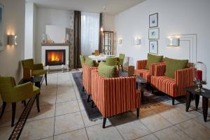 ein Wohnzimmer mit Stühlen, einem Tisch und einem Kamin in der Unterkunft Hotel Bristol Relais du Silence Superior in Adelboden