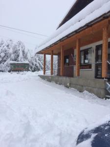 um edifício coberto de neve com um comboio à sua frente em Chalet-Hôtel du Borderan em La Clusaz