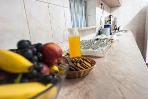 - un comptoir avec un bol de fruits et une bouteille de jus d'orange dans l'établissement Hotel Est, à Bucarest