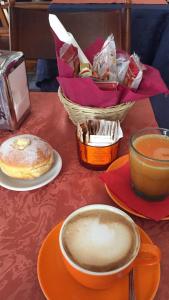 - une table avec des assiettes de nourriture et une tasse de café dans l'établissement Locanda San Paolo, à Monza