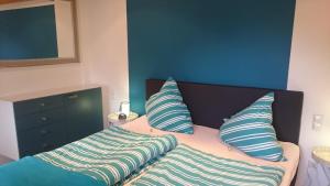 a bed with blue and white pillows on it at Haus Winkelchen in Cochem