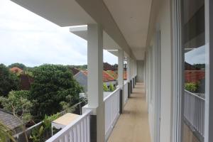 an empty porch of a house with white columns at Adi Bali Homestay in Uluwatu