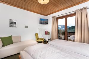 - une chambre avec un lit et un canapé dans l'établissement Pension Margarete, à Zell am See