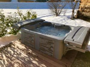 einen Whirlpool mit einer Bank im Schnee in der Unterkunft Chalet Luxe Les Mélèzes in Samoëns