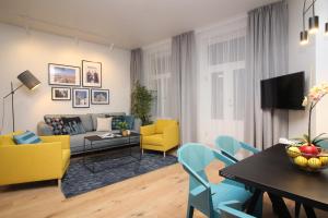 a living room with yellow and blue chairs and a table at Tallinn City Apartments Old Town Suites in Tallinn