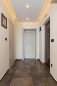 a hallway with white walls and a door and a tile floor at Apartment Milmari Sunny View G3 in Kopaonik