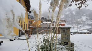 un cortile coperto da neve con un edificio giallo con neve di Hotel Castello a Montjovet