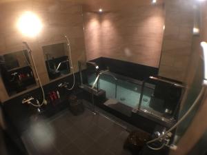 a bathroom with two urinals and a bath tub at Hotel Crown Hills Onahama in Iwaki