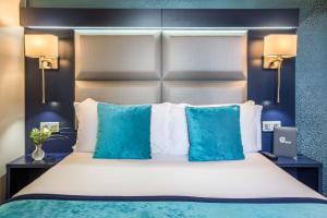 a bedroom with a large bed with blue pillows at Prince Albert Montmartre in Paris