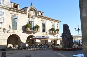 un bâtiment avec des tables et des chaises devant lui dans l'établissement Pazo de Mendoza, à Baiona