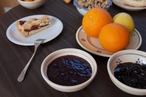 una mesa con platos de postres y cuencos de fruta en Hotel Donatello, en Alberobello