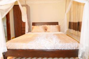 um quarto com uma cama de dossel em The Palms Beach Hotel em Entebbe