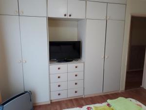 1 dormitorio con armarios blancos y tocador con TV en Casa Jardines del Mar, Puerto Montt, en Puerto Montt