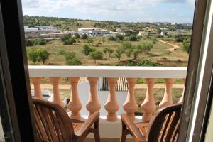 2 sedie su un balcone con vista su un campo di Casa Encosta do Sol a Lagos