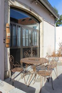 uma mesa e cadeiras sentadas em frente a uma janela em Ma Maison em Beaune