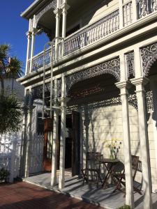 - un bâtiment blanc avec un balcon et une table dans l'établissement Artica Art & Accommodation, à Dunedin