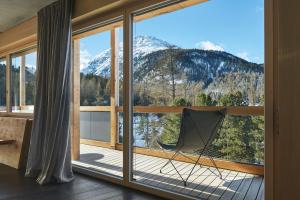 Habitación con ventana grande con vistas a la montaña. en Alpine Lodge Chesa a la Punt, en Pontresina