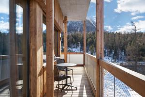 Habitación con balcón con mesa y sillas. en Alpine Lodge Chesa a la Punt, en Pontresina