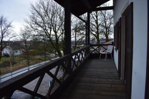 un portico in legno con sedia sul balcone di Beim Krahwirt a Deggendorf