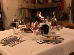 una mesa con un mantel blanco con copas y botellas de vino en Locanda Di Ansedonia - Ristorante GRIGL"io", en Orbetello