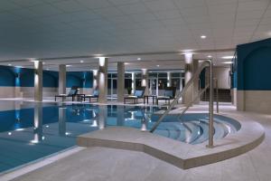 uma piscina num navio de cruzeiro com cadeiras e mesas em Van der Valk Hotel Gilze-Tilburg em Tilburgo