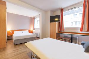 ein Hotelzimmer mit 2 Betten und einem Fenster in der Unterkunft City Residence Access Strasbourg in Straßburg