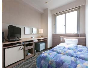 Onomichi Daiichi Hotel في أونوميتشي: غرفه فندقيه سرير وتلفزيون