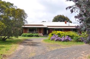 una casa con una strada sterrata davanti di Fairy Wren Cottage Country to Coast Retreat a Wallington