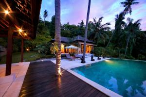 a backyard with a swimming pool and a house at Villa Marley in Senggigi 