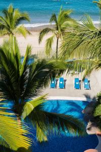 una vista aerea di una spiaggia con sedie e palme di Hotel El Pescador a Puerto Vallarta