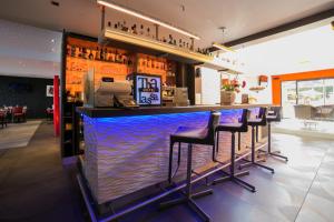 a bar with purple bar stools in a restaurant at Le Thalassa Hôtel & Spa in Camaret-sur-Mer