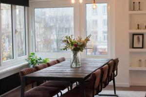 een eettafel met stoelen en een vaas met bloemen bij #Kaaistraat2 in Oostende