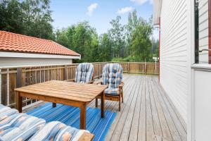 una terraza de madera con 2 sillas y una mesa de madera en Ferienhaus am Mycklaflon, en Eksjö