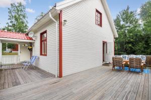 una terraza de madera con sillas y una mesa en una casa en Ferienhaus am Mycklaflon, en Eksjö