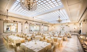 - une salle de banquet avec des tables et des chaises blanches dans l'établissement Villa Abbazia - Liburnia, à Opatija