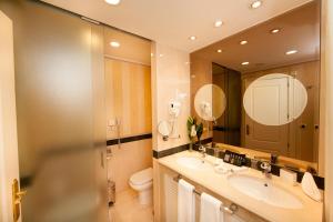 La salle de bains est pourvue de 2 lavabos, de toilettes et d'un miroir. dans l'établissement Apartamentos Guadalpin Boutique, à Marbella