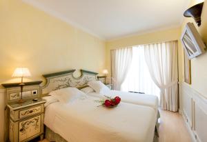 une chambre d'hôtel avec un lit orné d'une fleur dans l'établissement Apartamentos Guadalpin Boutique, à Marbella