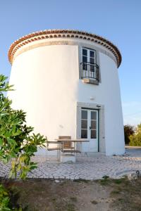 een wit gebouw met een tafel ervoor bij Ha Mar ao Luar in Setúbal