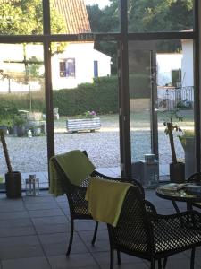 een afgeschermde veranda met 2 stoelen en een tafel en stoelen met handdoeken bij Hotel Borrby in Borrby