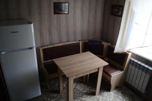 een kleine keuken met een tafel en stoelen en een koelkast bij Apartmens on Geroiv ATO in Krivoy Rog