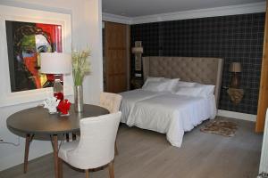 a bedroom with a bed and a table and chairs at Principia Suites in León