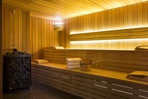 d'un sauna avec un banc, des serviettes et un éclairage. dans l'établissement Araucaria Hotel & Spa, à La Plagne