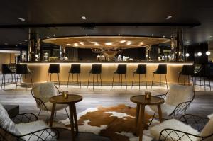 - un bar avec des chaises et des tables dans une pièce dans l'établissement Araucaria Hotel & Spa, à La Plagne