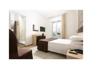 a bedroom with a bed and a desk and a chair at Hotel Gardenia in Lido di Jesolo