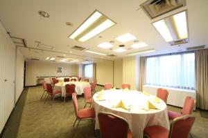 a conference room with tables and chairs and windows at HOTEL MYSTAYS PREMIER Narita in Narita