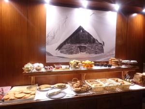 una línea de buffet con diferentes tipos de pasteles y pasteles en Hotel Fonfreda, en Vielha