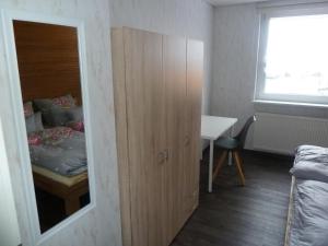 - une chambre avec une armoire, un lit et un bureau dans l'établissement im gelben Haus, à Trusen